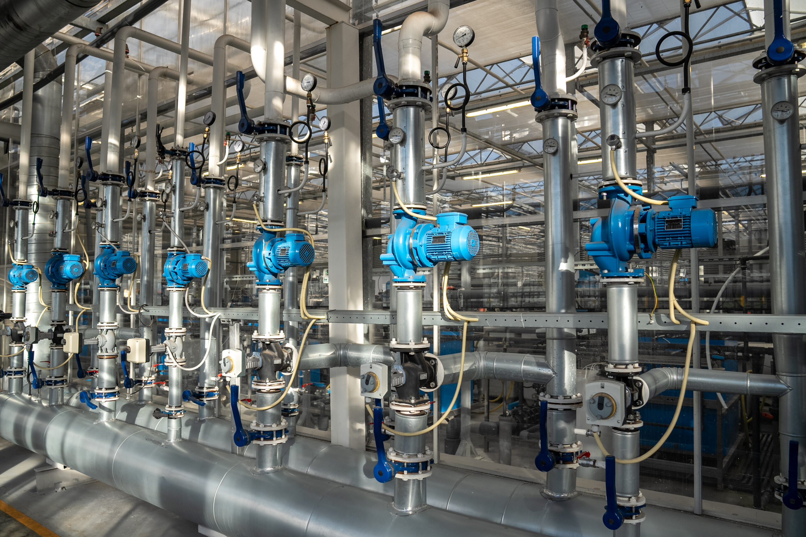 Heating and water supply system for greenhouses. Steel pipe framework with thermostats regulating temperature and pressure, ensuring optimal climate for plant growth, efficient temperature control